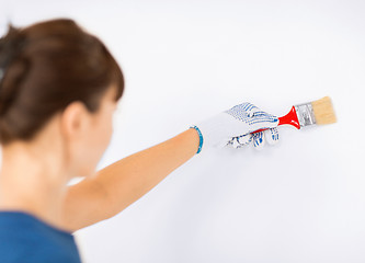 Image showing woman with paintbrush colouring the wall