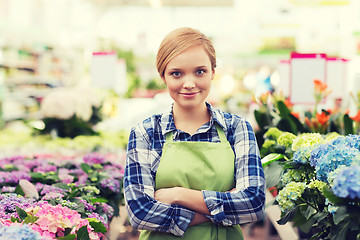 Image showing happy woman with flowers in greenhouse