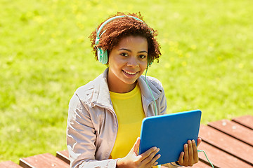 Image showing happy african woman with tablet pc and headphones