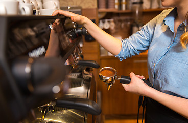 Image showing close up of woman making coffee by machine at cafe