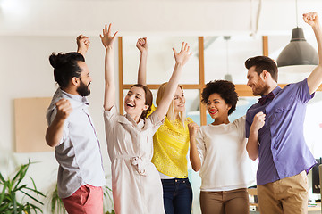 Image showing happy creative team celebrating victory in office