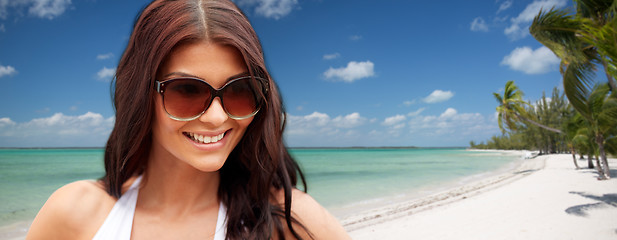 Image showing smiling young woman with sunglasses on beach