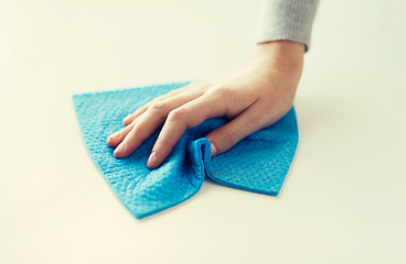 Image showing close up of hand cleaning table surface with cloth