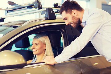 Image showing happy couple buying car in auto show or salon