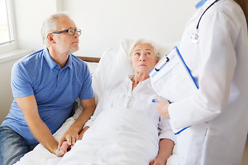 Image showing senior woman and doctor with clipboard at hospital