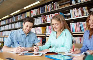 Image showing happy students with tablet pc in library