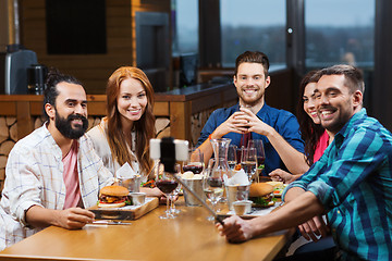 Image showing friends taking selfie by smartphone at restaurant