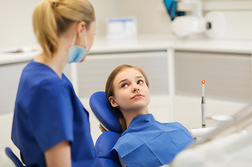 Image showing happy female dentist with patient girl at clinic