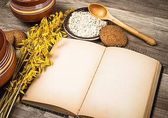 Image showing Oatmeal cookies and an old recipe book on the kitchen table 