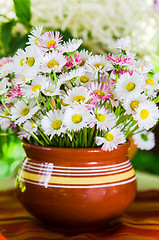 Image showing A bouquet of daisies in a pot at the table