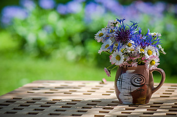 Image showing A bouquet of wildflowers in a circle on the table  