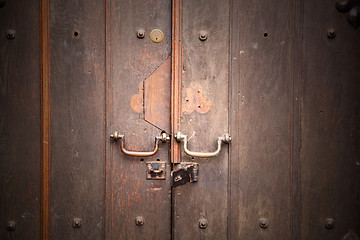 Image showing handle in london antique brown door  rusty  brass nail and light