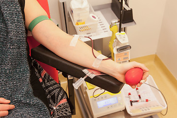 Image showing Donor in an armchair donates blood