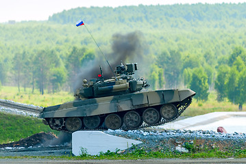 Image showing Tank T-80 overcomes a high concrete obstacle