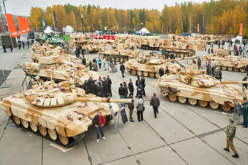 Image showing Visitors explore military vehicles on exhibition