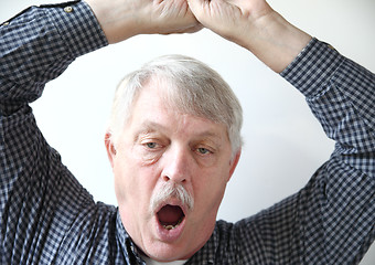 Image showing Sleepy older man yawns