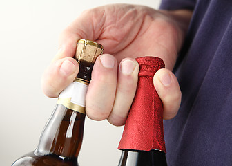Image showing Man holds beer bottles