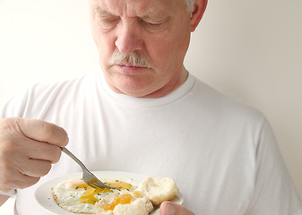 Image showing Man having fried eggs and biscuits