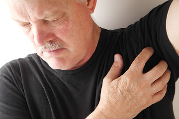 Image showing Senior man scratches under his arm.