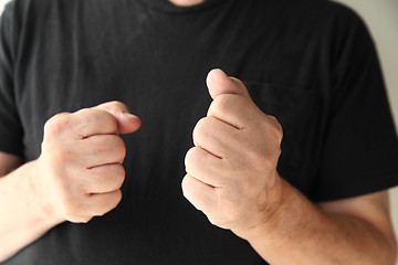 Image showing Older man making fists