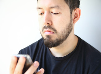 Image showing Young man checks his phone