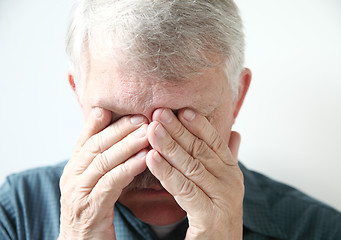 Image showing Older man covers eyes with hands