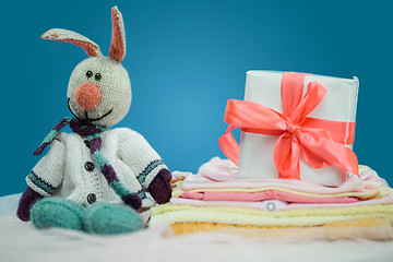 Image showing The baby clothes with a  white gift box