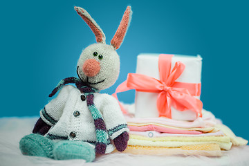Image showing The baby clothes with a  white gift box
