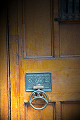 Image showing handle in london antique brown door  rusty  brass nail and light