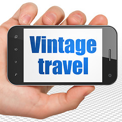 Image showing Tourism concept: Hand Holding Smartphone with Vintage Travel on display