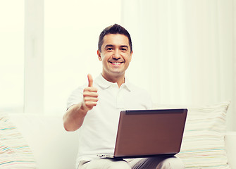 Image showing happy man working with laptop computer at home