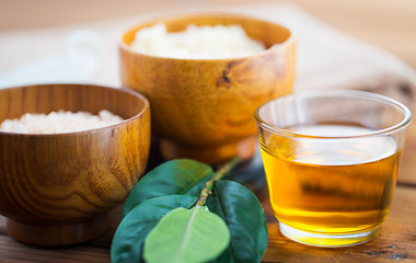 Image showing close up of honey in glass with leaves on wood