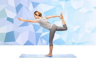 Image showing woman making yoga in lord of the dance pose on mat