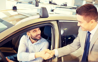 Image showing happy man with car dealer in auto show or salon