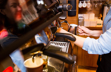 Image showing close up of woman making coffee by machine at cafe