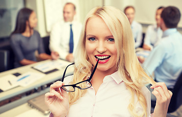 Image showing smiling businesswoman or secretary in office