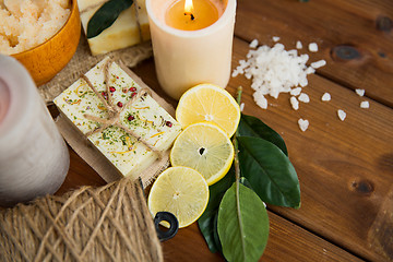 Image showing close up of natural soap and candles on wood