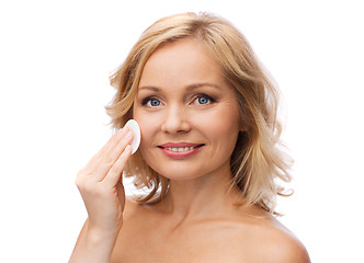 Image showing happy woman cleaning face with cotton pad