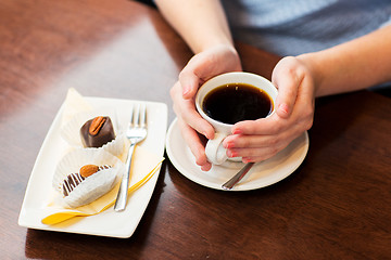 Image showing close up of woman holding coffee cup and dessert