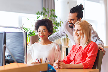 Image showing happy creative team with computer in office