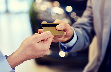 Image showing customer giving credit card to car dealer in salon