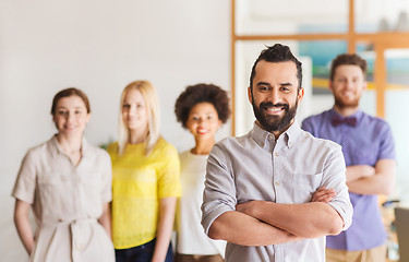 Image showing happy young man over creative team in office