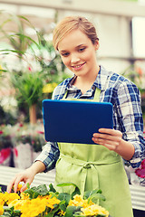 Image showing happy woman with tablet pc in greenhouse