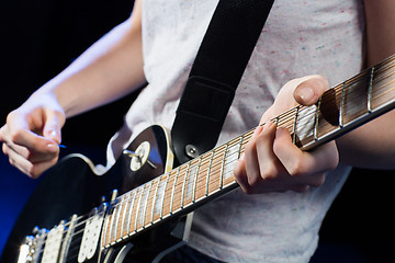 Image showing musician playing electric guitar with mediator