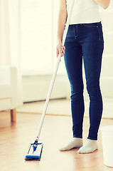 Image showing close up of woman with mop cleaning floor at home