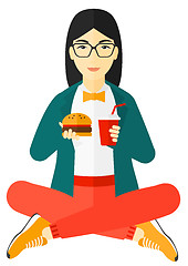 Image showing Woman eating hamburger. 