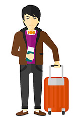 Image showing Man standing with suitcase and holding ticket.
