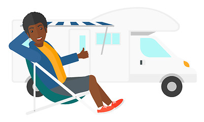 Image showing Man sitting in front of motorhome.