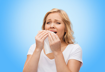 Image showing unhappy woman with paper napkin sneezing