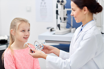 Image showing optician with trial frame and girl at clinic